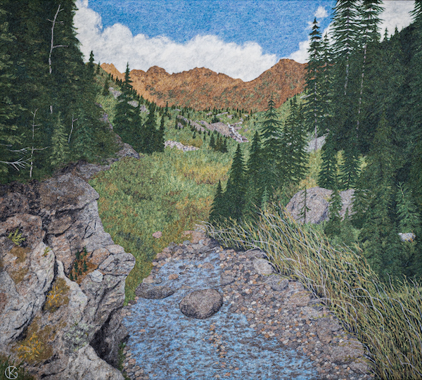 Felted wool artwork of a mountain stream, with rusty-red mountain peaks in the distance