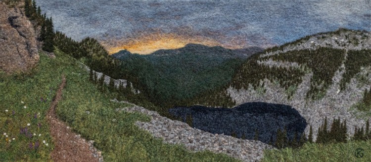 Felted wool artwork of a trail above an alpine lake at dawn