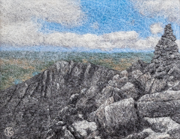 Felted wool artwork of a snow covered stack of rocks and a mountain ridge