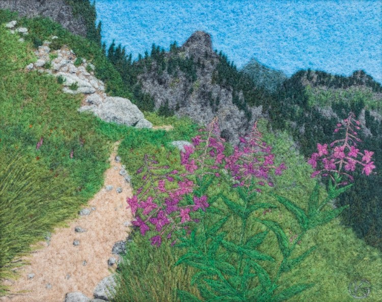 Felted wool artwork of pink flowers in the foreground with a trail leading away to mountain peaks